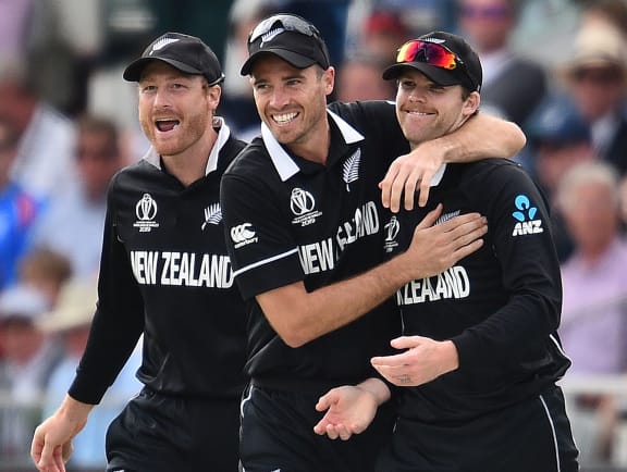 New Zealand's Lockie Ferguson (R) celebrates after catching the ball to take the wicket of England's captain Eoin Morgan for nine runs during the 2019 Cricket World Cup final