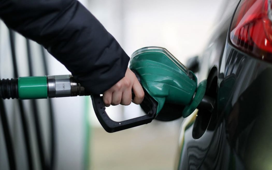 A motorist uses a pump as they re-fuel their car with unleaded petrol at a filling station in central London