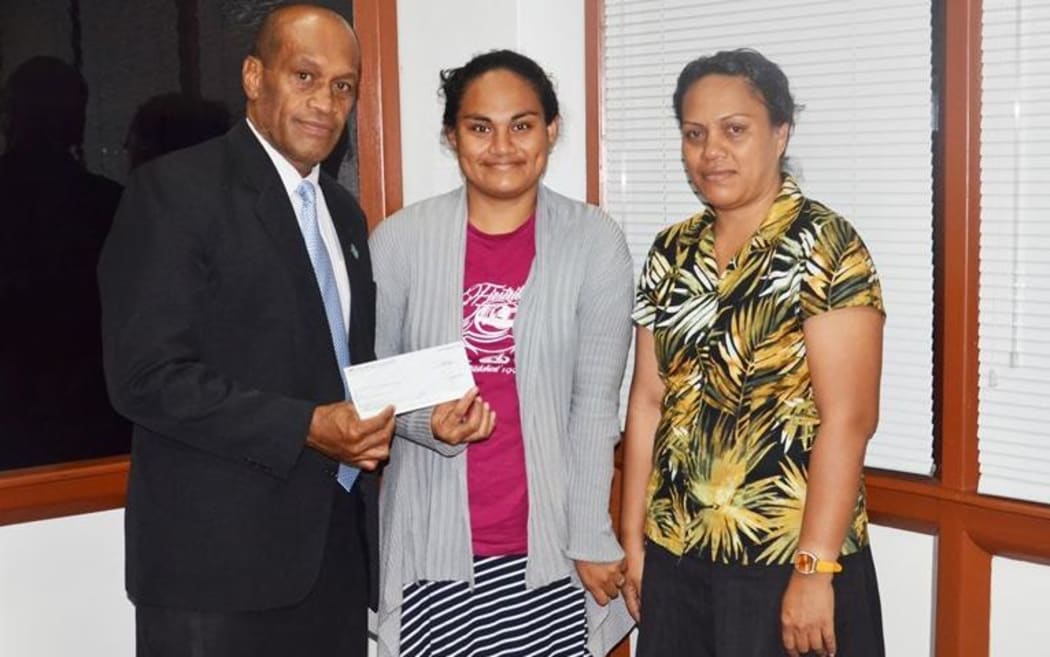 Jone Usamate presents the cheque to Rejieli Marieha Fagmanue and her daughter.