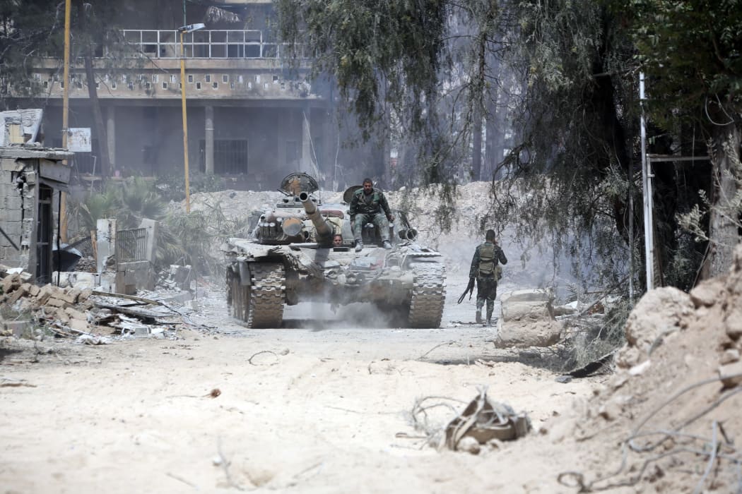 Syrian Army soldiers advance on the eastern outskirts of Douma on April 8, 2018, as they continue their fierce offensive to retake the last opposition holdout in Eastern Ghouta.