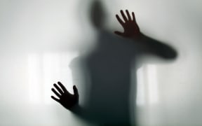 Shadow figure behind glass silhouette