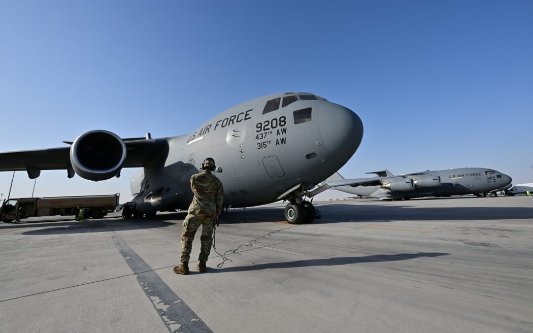 A US military transport aircraft, which will carry humanitarian aid parcels for the Gaza Strip, is pictured on the tarmac at the Al-Udeid air base southwest of Doha on March 21, 2024. (Photo by Giuseppe CACACE / AFP)