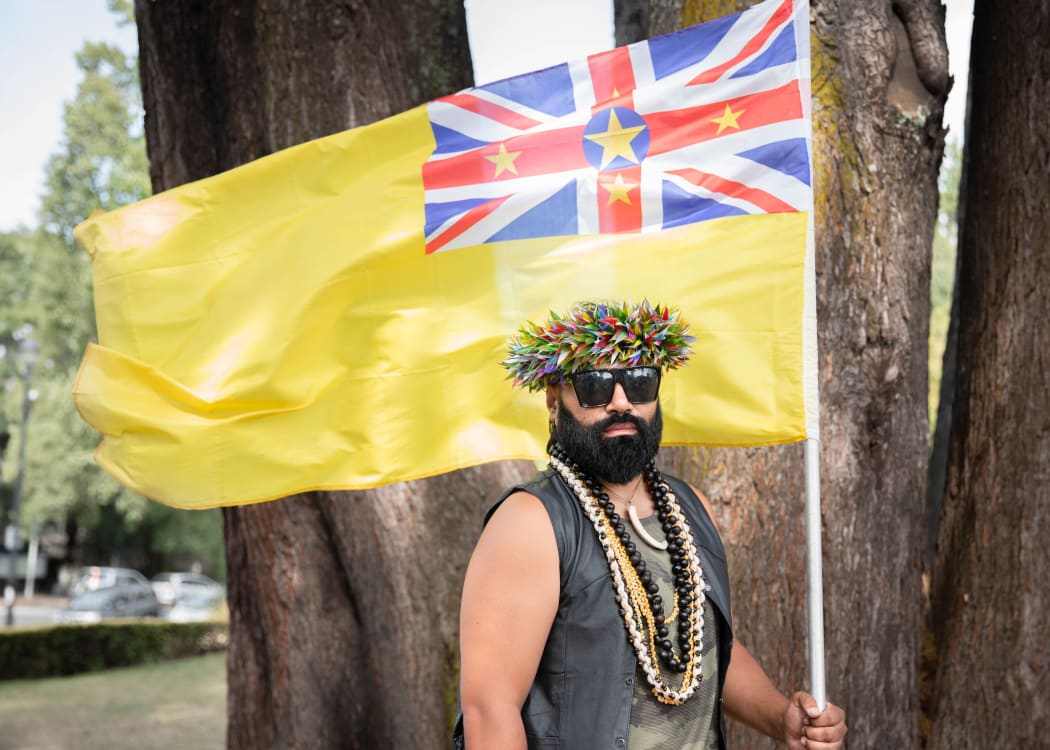 Joseph Tavita Ogotau-Wright holding a Nuien flag at OurMarch in Auckland
