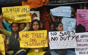 Junior doctors in India hold placards in a government hospital, calling for justice for a doctor who was raped and killed, and demanding safety in the hospital, on 11 August, 2024.