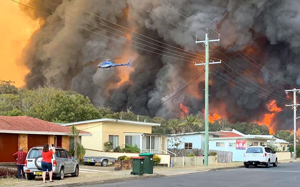 Flames from an out of control bushfire seen from a nearby residential area in Harrington, some 335km northeast of Sydney.