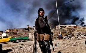 A member of Iraq's elite Rapid Response Division holds position in the northern city of Mosul as they continue the offensive to retake the city's western half from Islamic State (IS).