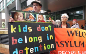 People hold placards at a protest outside an immigration office in Sydney in 2016.