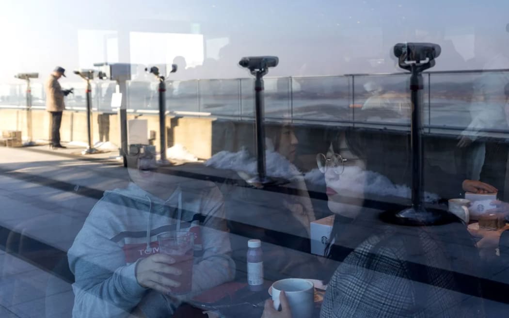Customers inside the Starbucks coffee shop with views of North Korea.