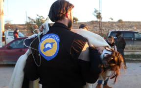 A wounded Syrian, who was evacuated from rebel-held neighbourhoods in the embattled city of Aleppo, is carried by a medic as she arrives in the opposition-controlled Khan al-Aassal region.