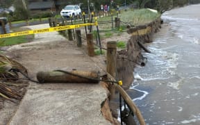 Damage to a walkway and bank facing the shore.