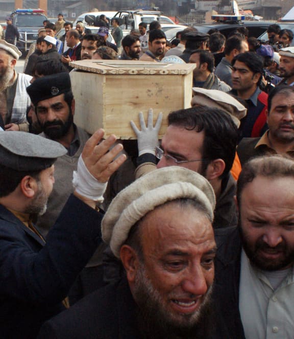 Relatives carry the coffin of a student from a hospital following the attack.
