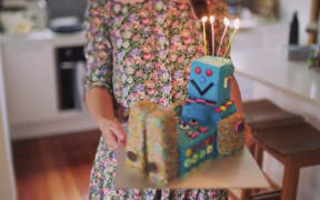 Woman holding children's birthday cake.