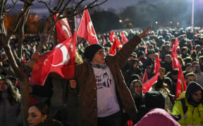 Supporters of Istanbul metropolitan Mayor Ekrem Imamoglu take part in a demonstration outside Istanbul municipality against his detention over a corruption probe, in Istanbul on March 19, 2025. Mayor of Istanbul Ekrem Imamoglu, the main opponent of Turkish President, was arrested on March 19, 2024 in the morning along with dozens of his aides, elected representatives and members of his party, accused of 'corruption', according to the city's public prosecutor. (Photo by KEMAL ASLAN / AFP)