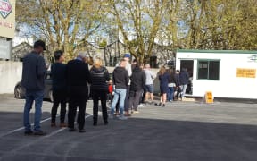 Advance voters queue out the door of this polling place at a supermarket in Auckland CBD.