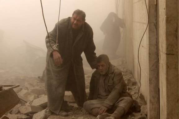 A Syrian helps an injured man following an airstrike in Aleppo's Maadi suburb.