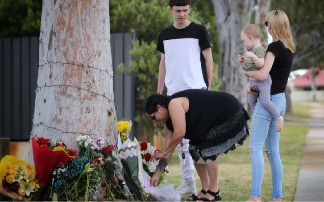 Mourners lay flowers at a memorial for Cassius Turvey on Patterson Road in Middle Swan.
