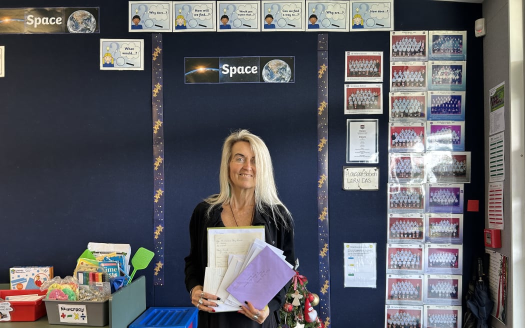Photo of a woman holding a pile of letters.
