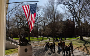 CAMBRIDGE, MASSACHUSETTS - APRIL 17: People gather to take photos with the John Harvard Statue at Harvard University on April 17, 2025 in Cambridge, Massachusetts. The Trump administration announced that it would block Harvard University from receiving $2.2 billion in federal grants and $60 million in contracts after the school refused demands to adopt new policies relating to student and faculty conduct, admissions, anti-semitism on campus and DEI.   Sophie Park/Getty Images/AFP (Photo by Sophie Park / GETTY IMAGES NORTH AMERICA / Getty Images via AFP)