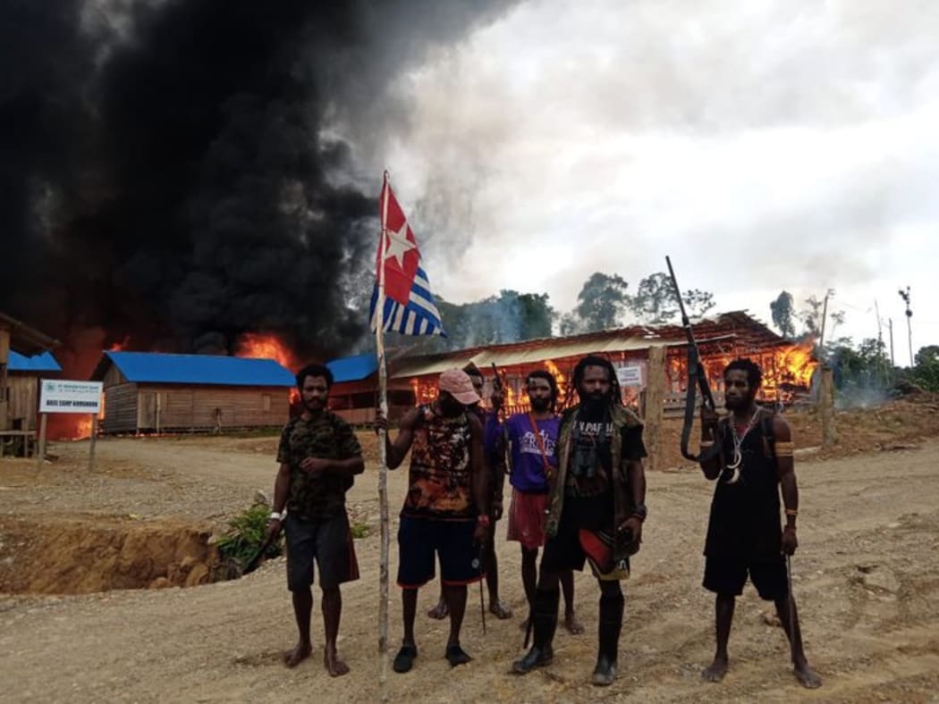 West Papua Liberation Army members outside the torched base camp of Indonesian logging company PT Bangun Katu Irian