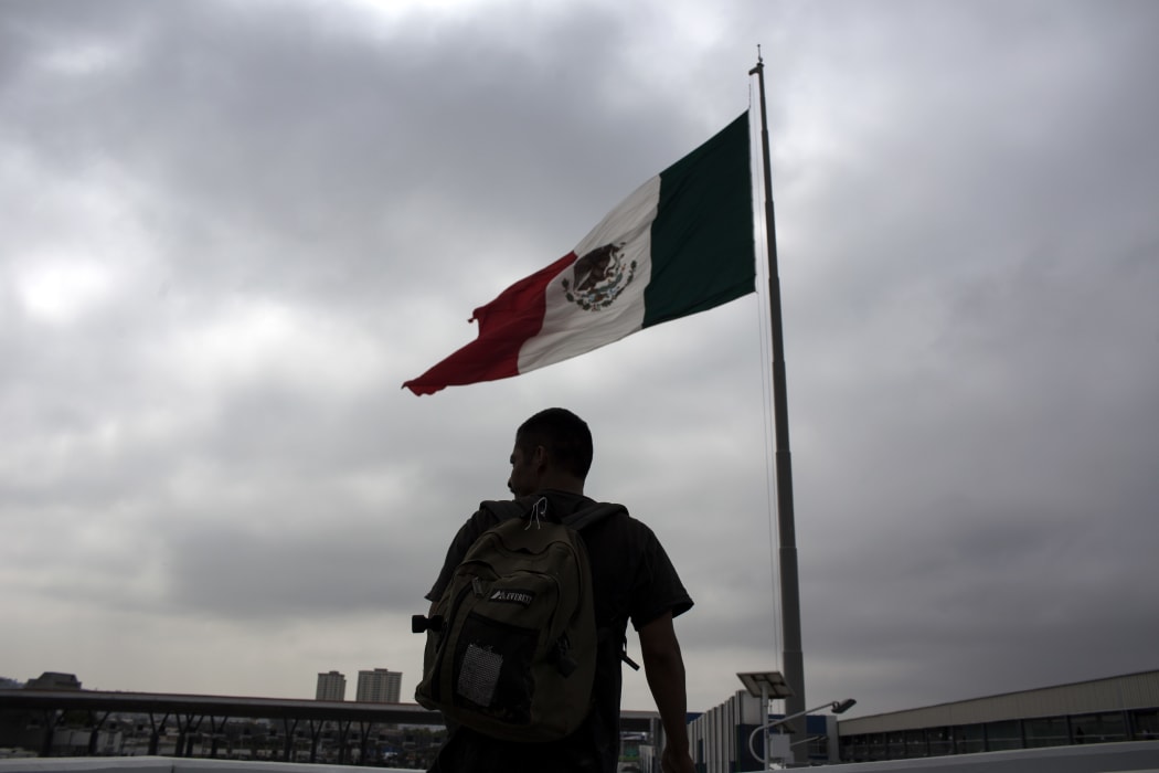 A Mexican deported from the US is seen next to a Mexican national flag at El Chaparral repatriation center in Tijuana, northwestern Mexico, in the border with the US.