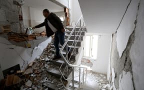 A man enters his damaged home to take his belongings in the earthquake hit city of Durres, western Albania on December 2, 2019.