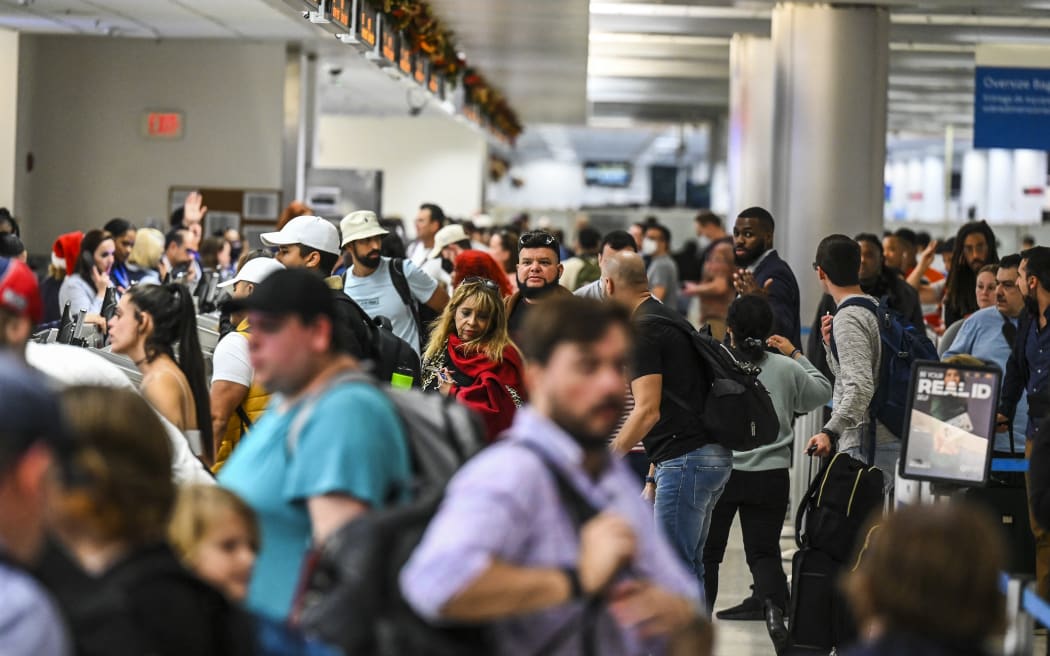 Travellers wait in line to check in at Miami International Airport during a winter storm ahead of the Christmas holiday in Miami, Florida, on December 23, 2022.