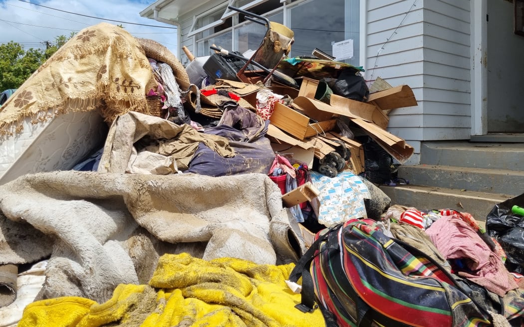 Vasiti Pele and her husband Siosaia's sodden belongings piled outside their West Auckland home after their house flooded.