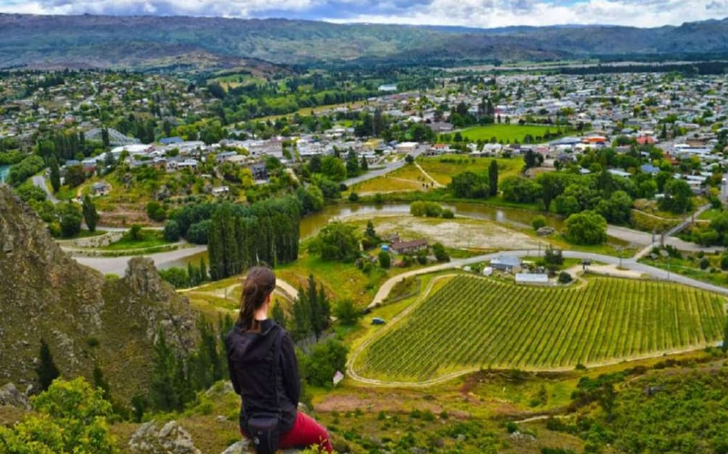 A person looks at the view over Alexandra, in Central Otago, on a sunny day.