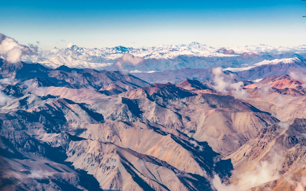 Aerial view from window plane of andes range mountains over chilean territory.