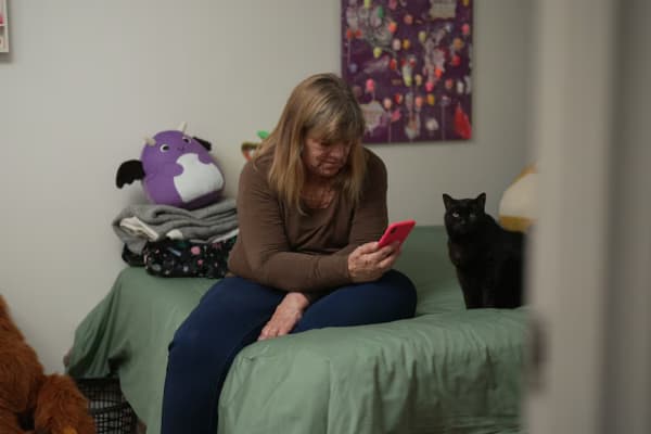 Hayley sits on her bed, looking at her phone.