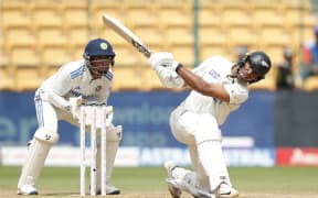 Rachin Ravindra of New Zealand hits over the top for six during the first test against India.