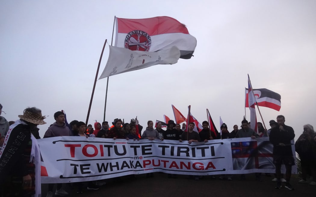 Hīkoi leader Eru Kapa-Kingi addresses the crowd in the early morning mist at Cape Rēinga.