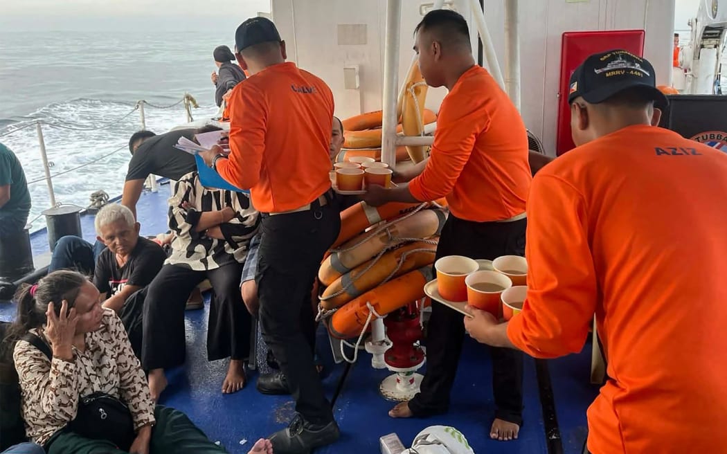 This handout photo from the Philippine Coast Guard (PCG) taken and received on January 26, 2026 shows coast guard crew attending to the survivors of the sunken M/V Trisha Kerstin 3 in waters off Basilan province. A ferry carrying 342 passengers sank on January 26 morning in the southern Philippines, leaving at least eight dead, a local mayor said. (Photo by Handout / Philippine Coast Guard (PCG) / AFP) / RESTRICTED TO EDITORIAL USE - MANDATORY CREDIT "AFP PHOTO /  PHILIPPINE COAST GUARD (PCG)" - HANDOUT - NO MARKETING NO ADVERTISING CAMPAIGNS - DISTRIBUTED AS A SERVICE TO CLIENTS