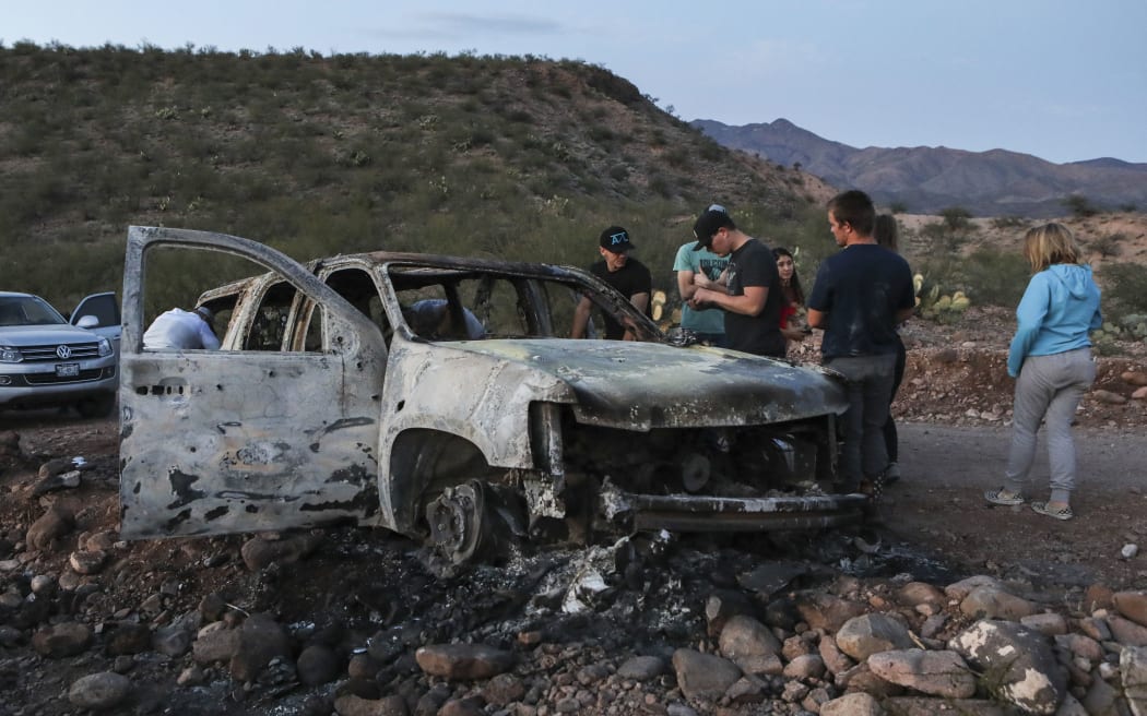 Members of the Lebaron family watch the burned car where part of the nine murdered members of the family were killed and burned during an gunmen ambush on Bavispe, Sonora mountains, Mexico, on November 5, 2019.