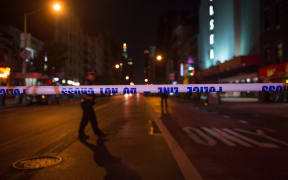 Police walk past police tape on a blocked off road near the site of the explosion on West 23rd Street.