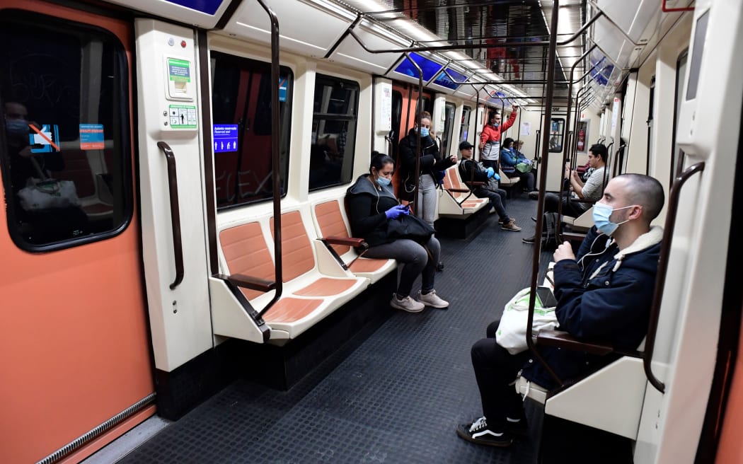 Commuters wearing face masks on a train at the Atocha Station in Madrid on 13 April 2020
