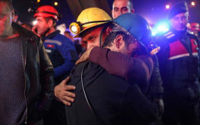 Relatives and friends of the coal miners comfort each other.
