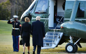 US President Donald Trump and First Lady Melania make their way to board Marine One before departing from the South Lawn of the White House in Washington, DC on January 20, 2021.
