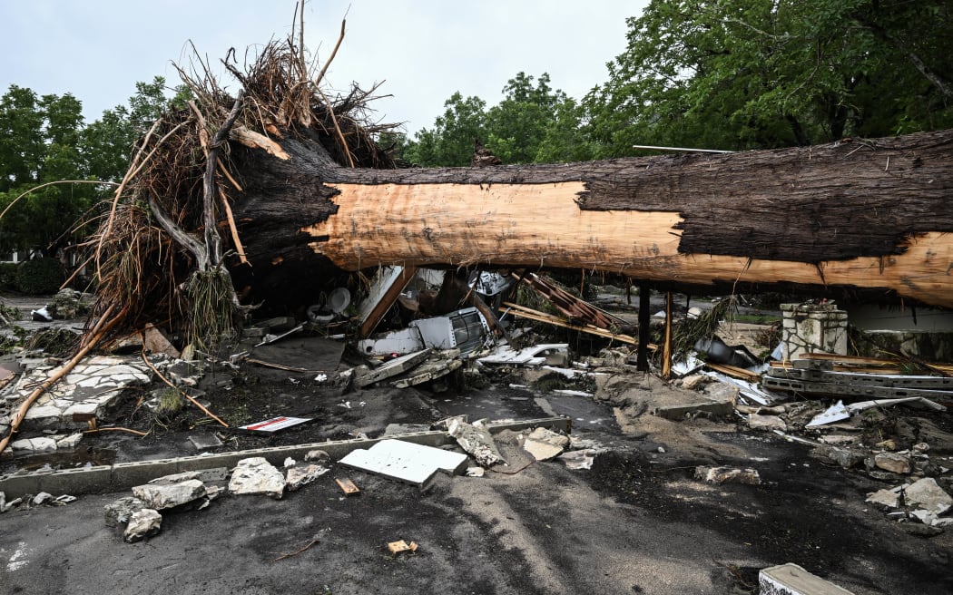 A large tree is uprooted outside of a home near Camp Mystic, the site of where at least 20 girls went missing after flash flooding in Hunt, Texas, on July 5, 2025. Rescuers were on Saturday searching for more than 20 girls missing from a riverside summer camp in the US state of Texas, after torrential rains caused devastating flooding that killed at least 27 people -- with more rain on the way. "So far, we've evacuated over 850 uninjured people, eight injured people and have recovered 27 deceased fatalities at this time. Of these 27, 18 are adults, nine are children," said Kerr Country Sheriff Larry Leitha on July 5. (Photo by RONALDO SCHEMIDT / AFP)