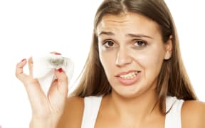 young beautiful woman removing makeup from her face
