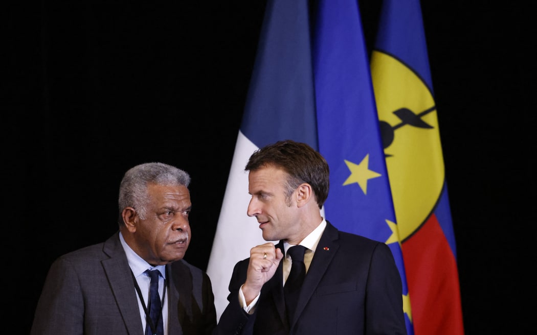 Le chef du gouvernement de la Nouvelle-Calédonie, Louis Mapou, s'entretient avec le président français Emmanuel Macron lors d'une cérémonie de signature à la Maison de l'APEC à Port Moresby le 28 juillet 2023. (Photo de Ludovic MARIN / AFP)