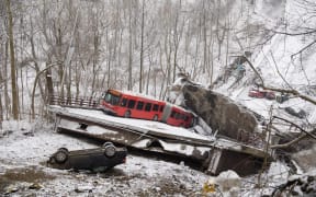 Vehicles including a Port Authority bus are left stranded after a bridge collapsed along Forbes Avenue in Pittsburgh, Pennsylvania on 28 January, 2022.