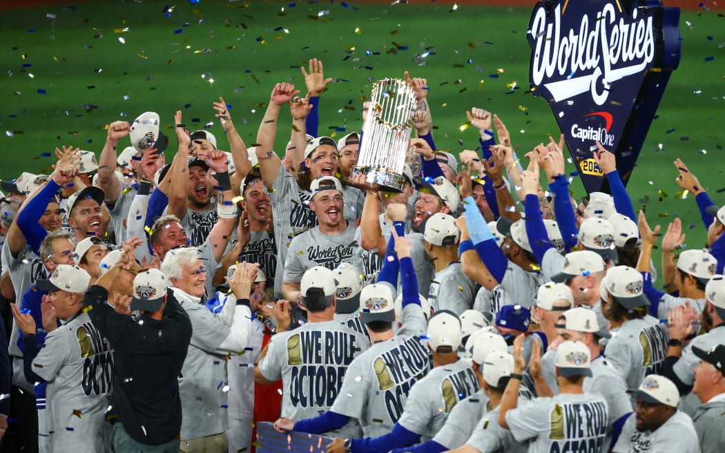 TORONTO, ONTARIO - NOVEMBER 02: Clayton Kershaw #22 of the Los Angeles Dodgers raises the Commisioner's Trophy after defeating the Toronto Blue Jays 5-4 in game seven of the 2025 World Series at Rogers Center on November 02, 2025 in Toronto, Ontario.   Vaughn Ridley/Getty Images/AFP (Photo by Vaughn Ridley / GETTY IMAGES NORTH AMERICA / Getty Images via AFP)