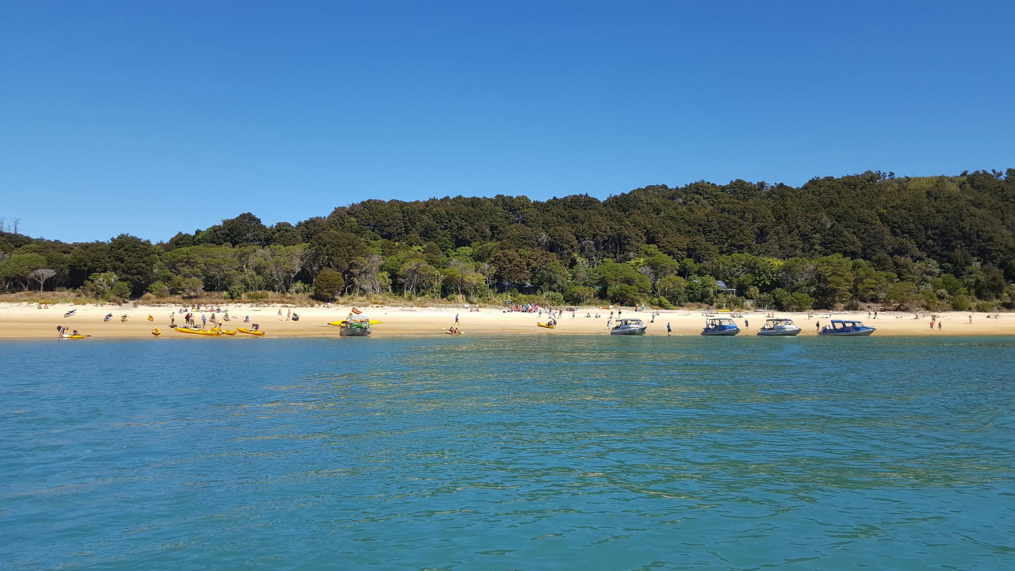 Boats and water taxis line the beach at Anchorage, Abel Tasman National Park in March 2017 - well after the peak tourist season