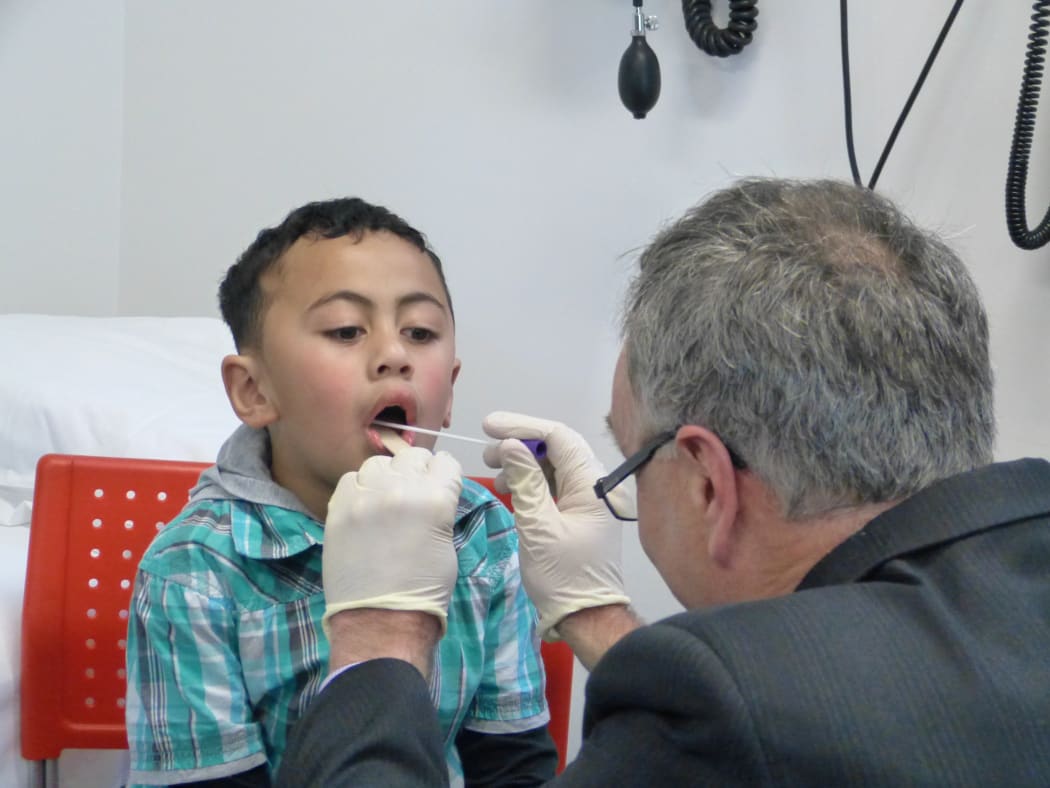Soloiautele (AJ) Taliulu being throat-swabbed by Dr Bryan Betty.