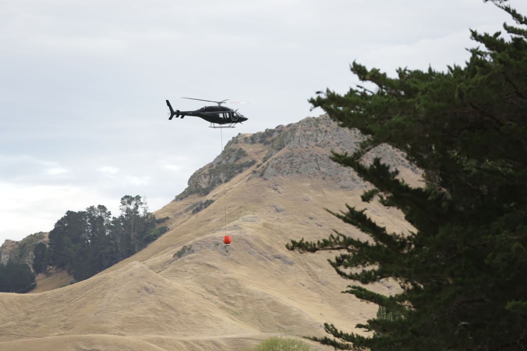 Helicopters with monsoon buckets work to douse the fires
