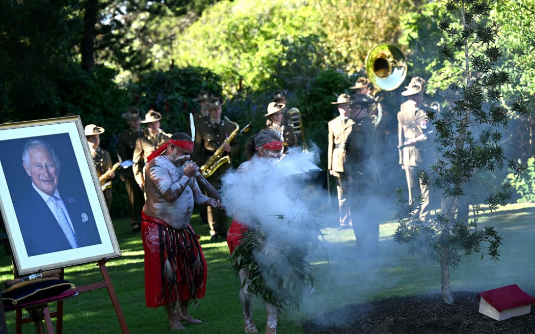 Indigenous men perform a traditional smoking ceremony at a tree planting event to commemorate the coronation of Britain's King Charles III, at  the Government House in Sydney on May 6, 2023. (Photo by Saeed KHAN / AFP)