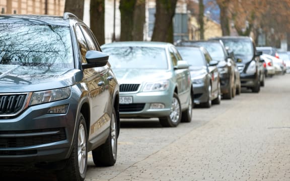 Cars parked in a row on a city street side.