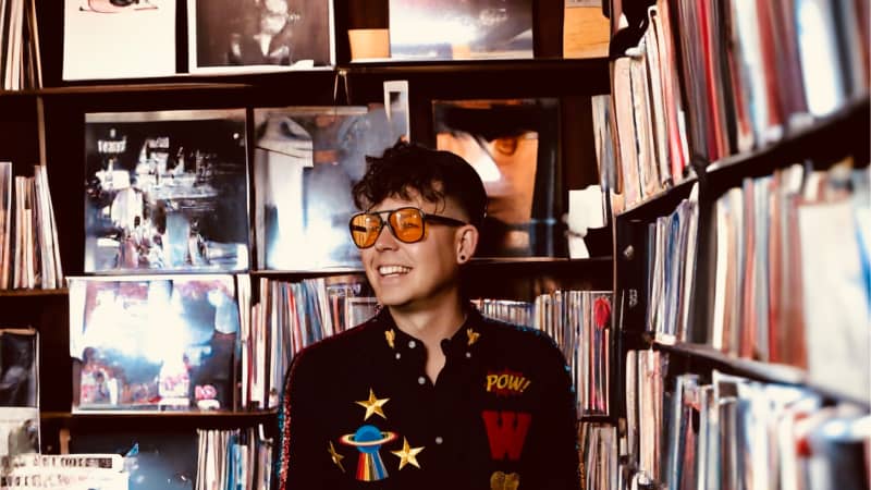 Josh Leys standing wearing glasses in a vinyl shop.