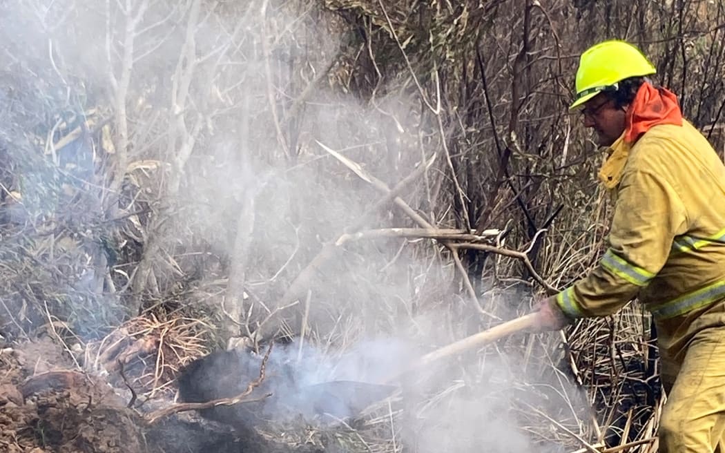 Gruelling physical work with hand tools and hoses is the only way to put out the Waipoua fire.